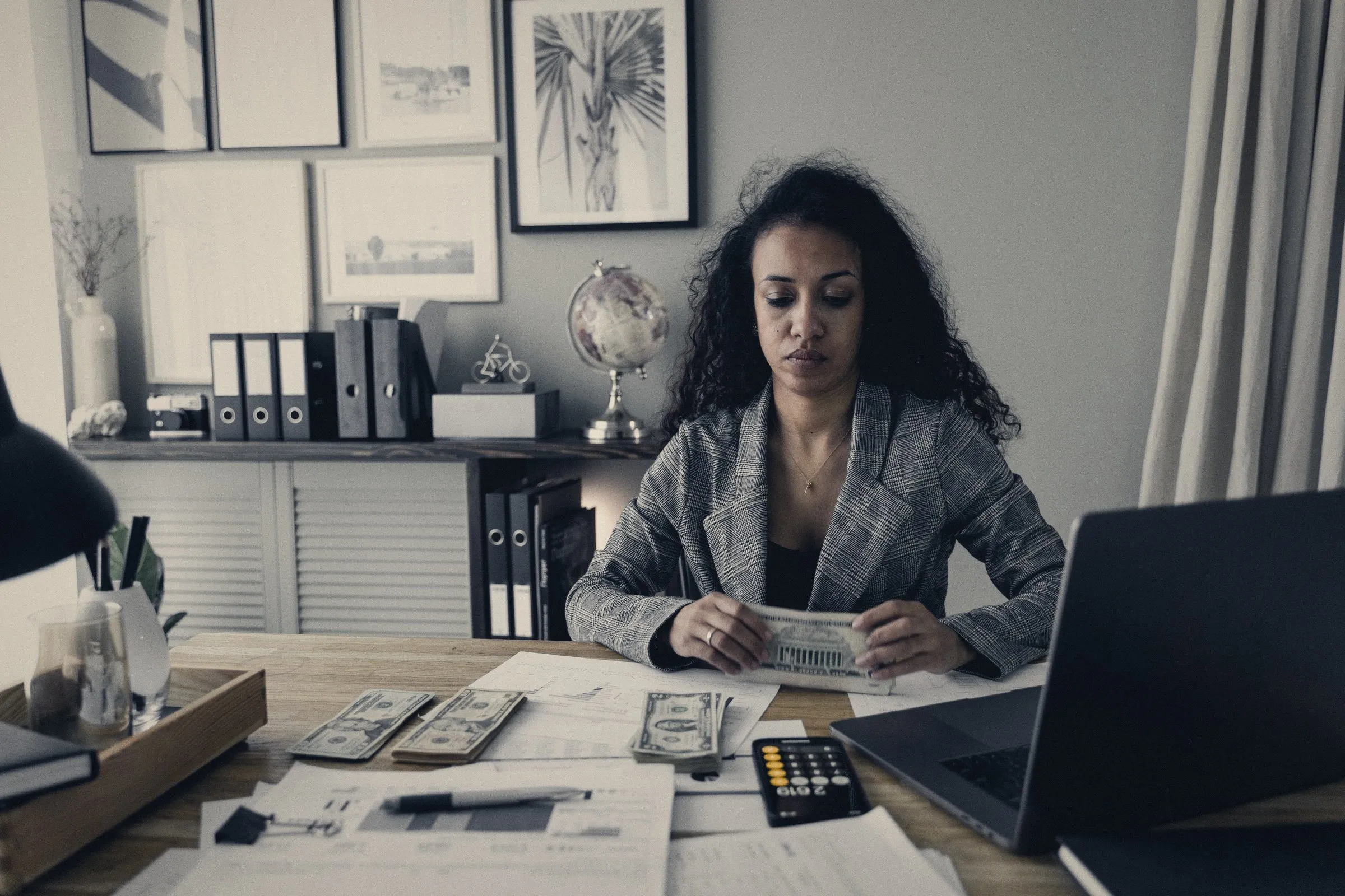 Persona contando dinero y revisando cuentas en un escritorio