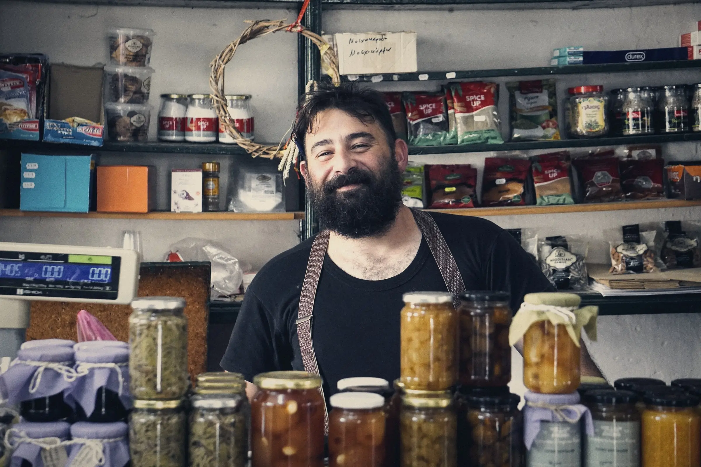 Tendero sonriendo detrás del mostrador de su tienda de conservas