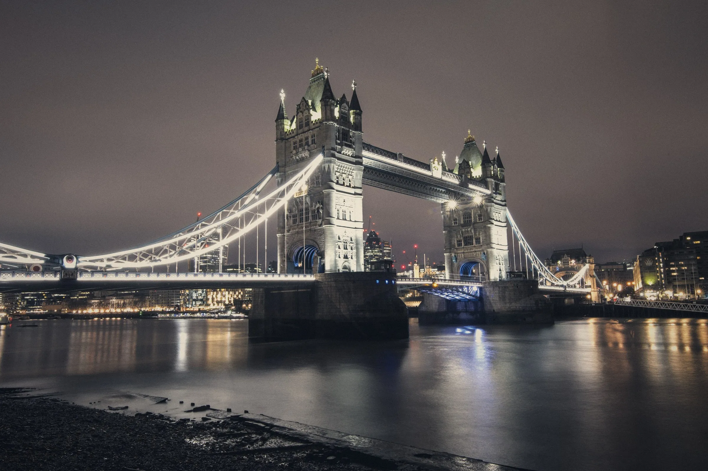 El Puente de la Torre de Londres iluminado de noche sobre el río Támesis