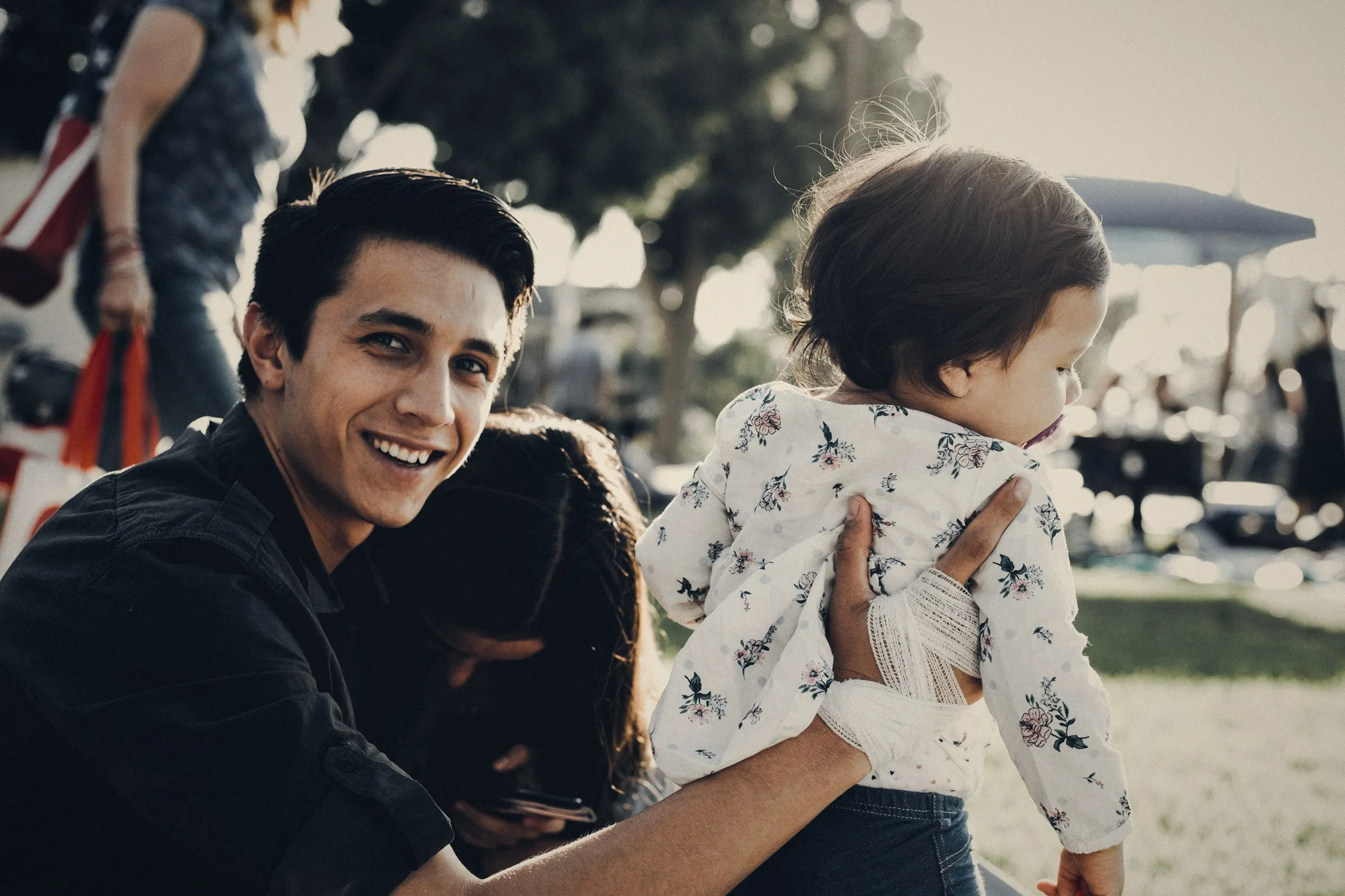 Padre sonriendo con su hija en brazos